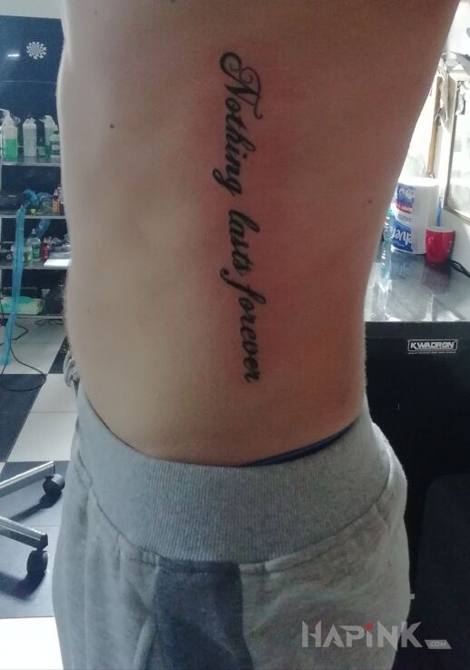 Tattoo Nic nie trwa wiecznie in lettering motif on the ribs
