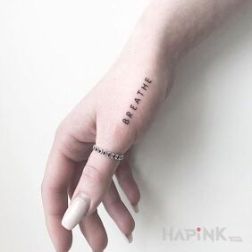 Tattoo Breathe on the hand motif: lettering