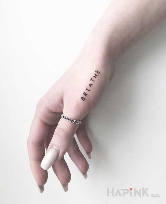 Tattoo Breathe in lettering motif on the hand
