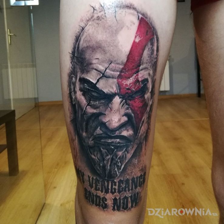 Tatuaż bog wojny w motywie twarze na nodze