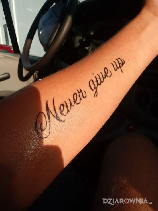 Tatuaż nigdy się nie poddawaj w motywie napisy na przedramieniu