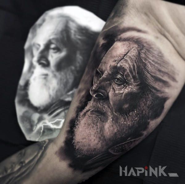 Tattoo Filmowy odyn in faces motif and realistic style on the upper arm
