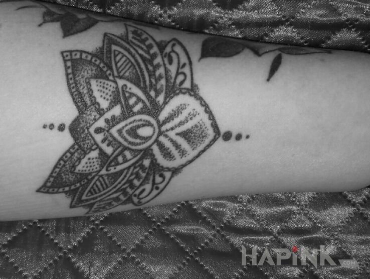 Tattoo Lotos in flowers motif on the forearm