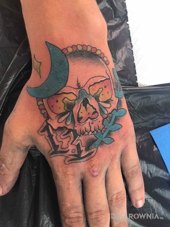 Tatuaż kolor w motywie czaszki na dłoni