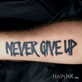 Tattoo Never Give Up on the forearm motif: lettering