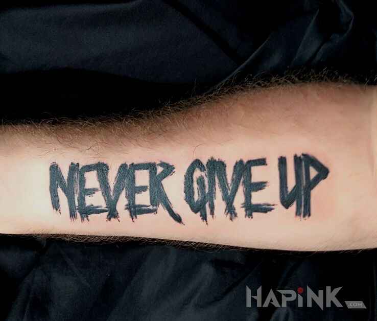 Tattoo Never Give Up in lettering motif on the forearm
