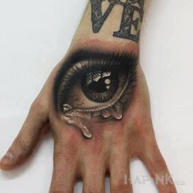 Tattoo Cloudy eye on the hand motif: lettering style: realistic