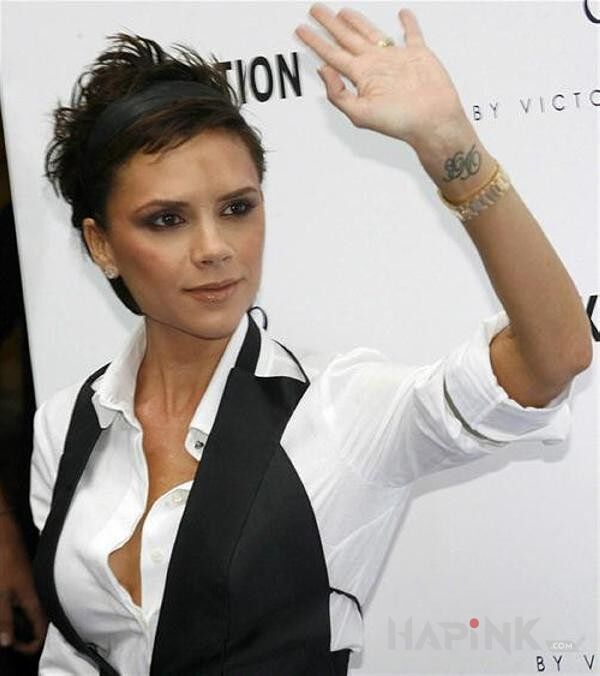 Tattoo Victoria Beckham podnosi rękę i widać dziarę na nadgarstku in famous people motif on the wrist