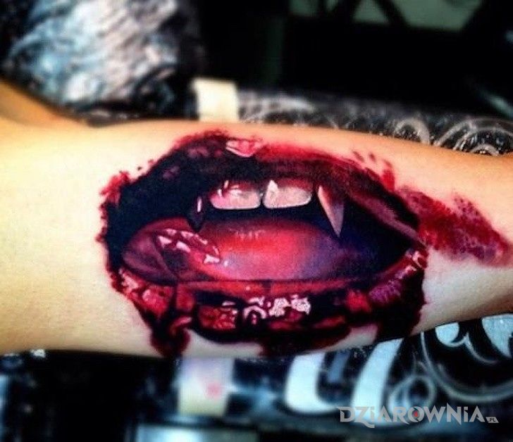 Tatuaż usta wampira w motywie demony na przedramieniu