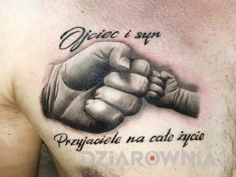 Wytatuowane dłonie na klatce piersiowej i tatuaż napis po polsku