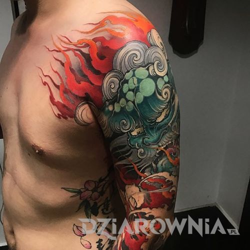 Japoński tatuaż w kolorze z lwem na męskim ramieniu
