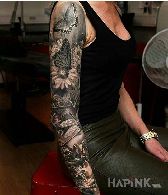Tattoo Motyle motylki in flowers motif on the upper arm