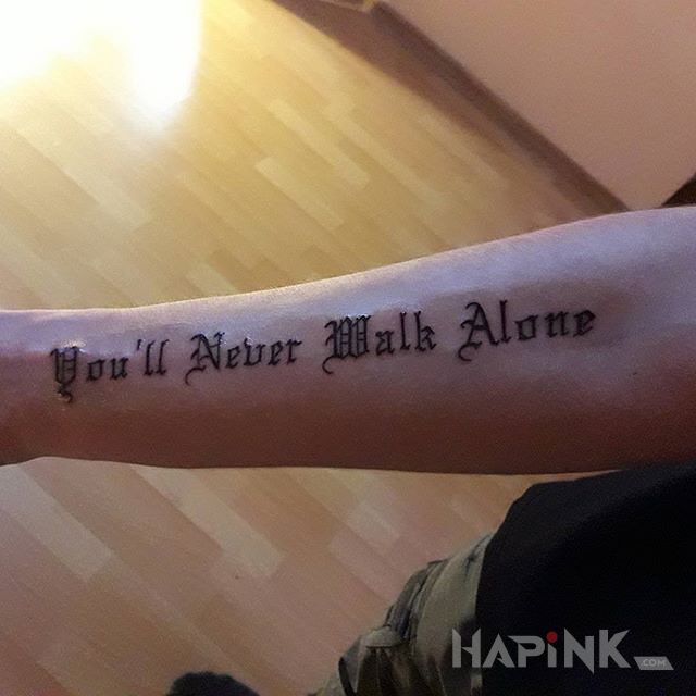 Tattoo You'll Never Walk Alone in lettering motif on the forearm
