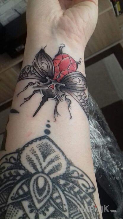 Tattoo Skarabeusz in butterflies motif on the wrist