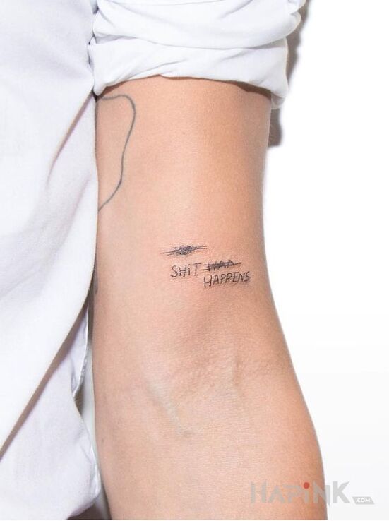 Tattoo Shit happens in lettering motif on the upper arm