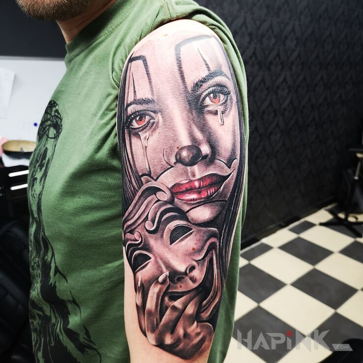 Tattoo Śmiech przez łzy. in faces motif on the upper arm