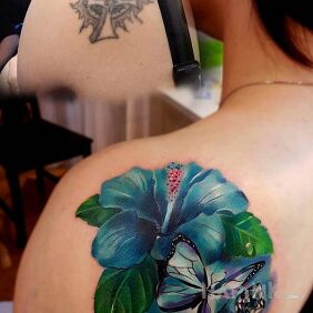 Tattoo Blue flower on the shoulder blades motif: butterflies style: realistic