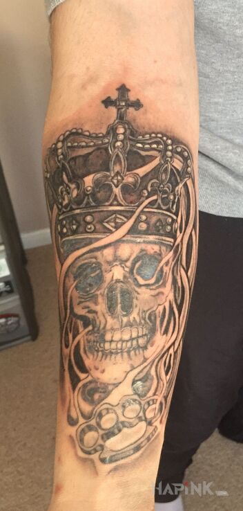 Tattoo Czaszka korona kastet in black and gray motif and realistic style on the forearm