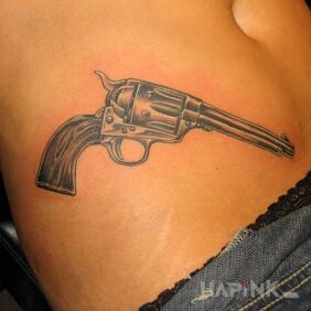 Tattoo Revolver on the stomach motif: black and gray style: realistic