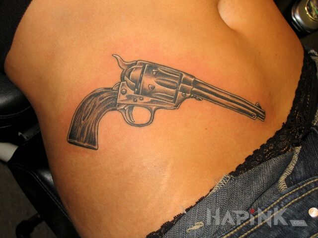 Tattoo Rewolwer in black and gray motif and realistic style on the stomach