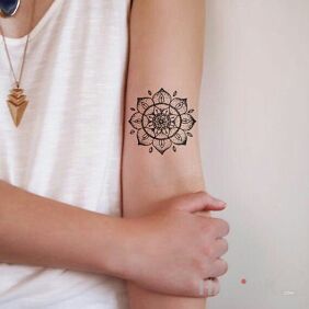 Tattoo Mandala on the upper arm motif: black and gray style: graphic / illustrative