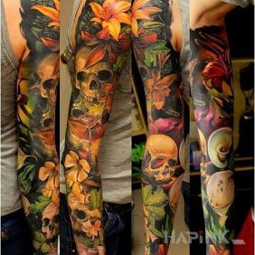Tattoo Skulls among the greenery on the upper arm motif: flowers style: realistic