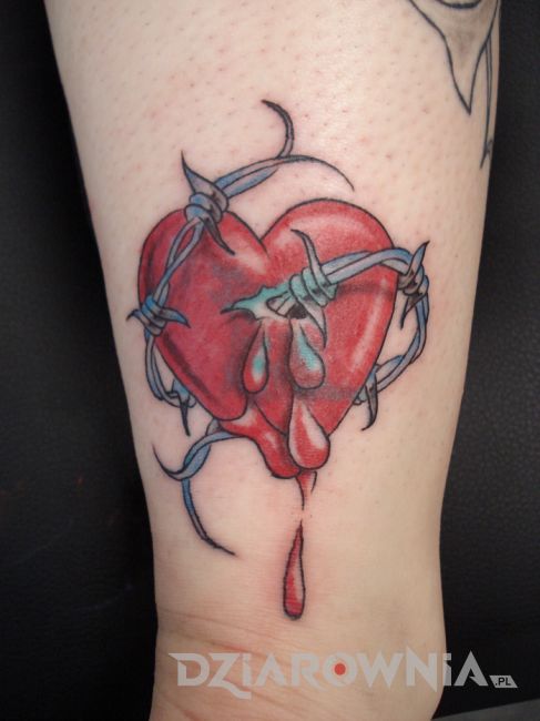 Kolorowy tatuaż serce owinięte drutem na nodze