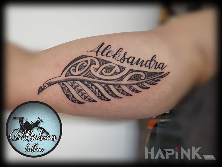 Tattoo Polinezyjski liść paproci z imieniem in flowers motif and Polynesian style on the upper arm