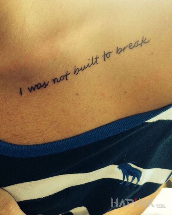 Tattoo Nie do złamania in lettering motif and calligraphy style on the collarbone