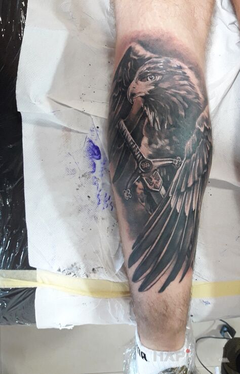 Tattoo Orzeł in objects motif and realistic style on the calf