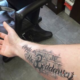 Tattoo Caption on the forearm motif: lettering style: calligraphy
