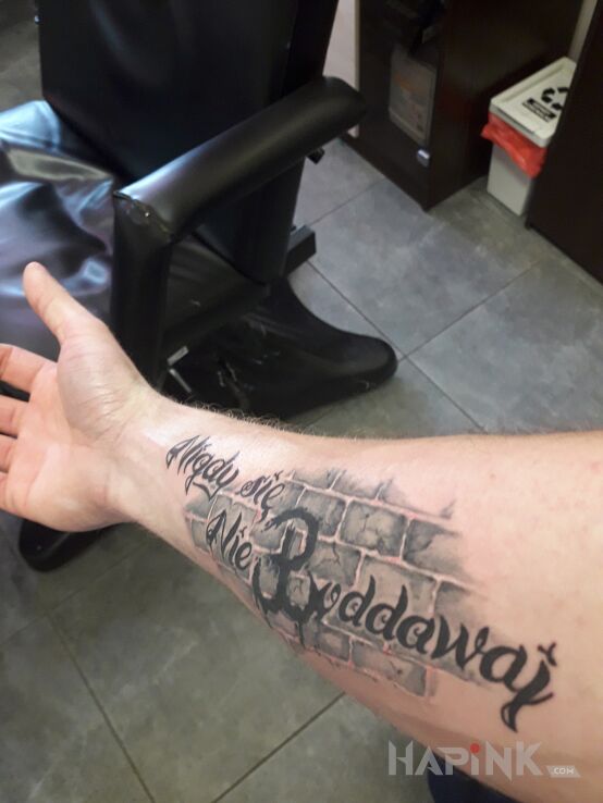 Tattoo Napis in black and gray motif and calligraphy style on the forearm