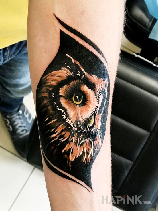 Tattoo Sowa in colorful motif and realistic style on the forearm
