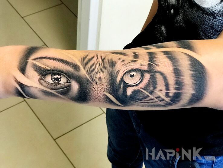 Tattoo Tygrys in faces motif and realistic style on the forearm