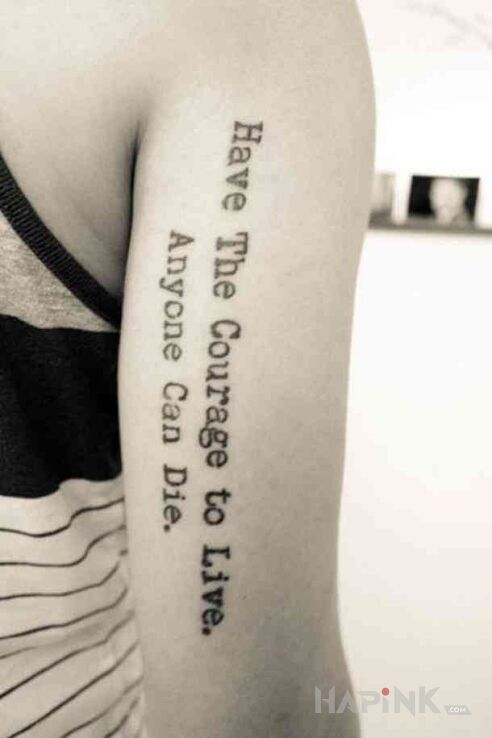 Tattoo Odwaga do życia in lettering motif and calligraphy style on the upper arm