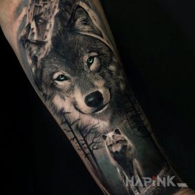 Tattoo Smiling wolf on the forearm motif: black and gray style: realistic
