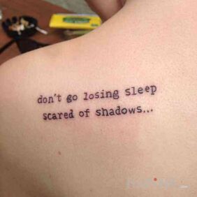 Tattoo Fear of shadows on the shoulder blades motif: lettering style: calligraphy