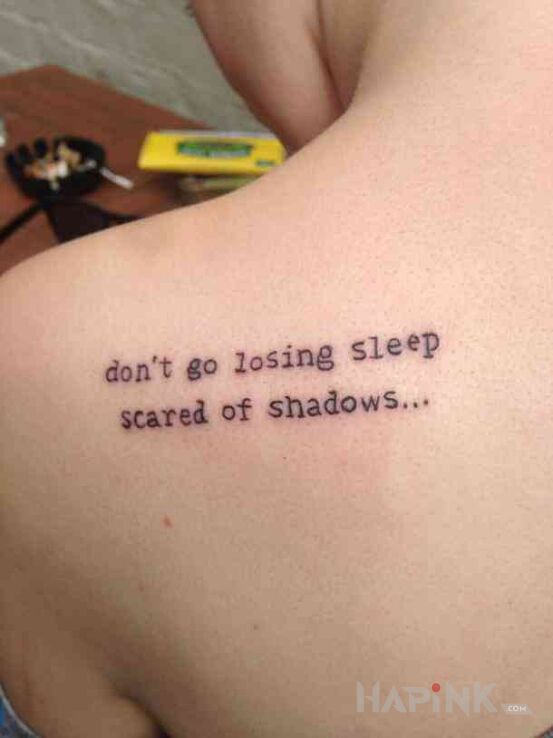 Tattoo Strach przed cieniami in lettering motif and calligraphy style on the shoulder blades