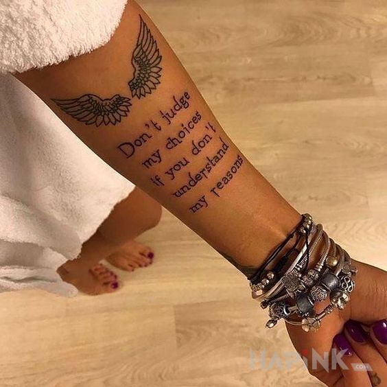 Tattoo Wlasne wybory in wings motif and calligraphy style on the forearm