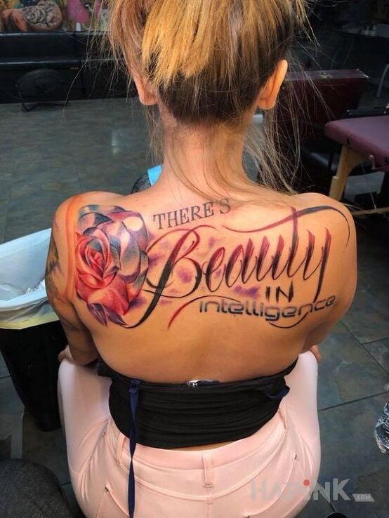 Tattoo Piękno inteligencji in flowers motif and calligraphy style on the shoulder blades
