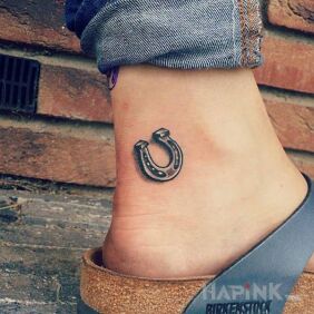 Tattoo Horseshoe on the foot motif: black and gray style: minimalistic