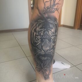 Tattoo Tiger among the trees on the calf motif: animals style: realistic