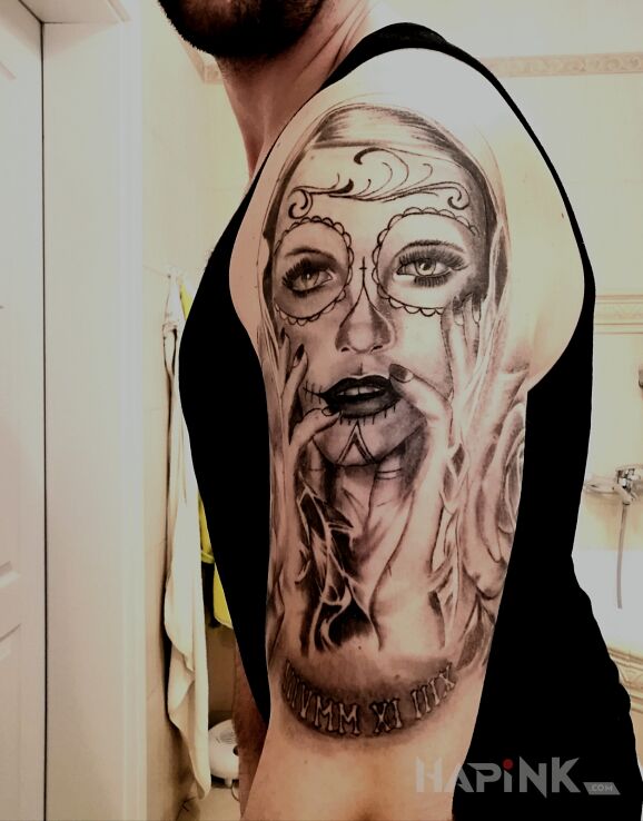 Tattoo Santa Muerte in black and gray motif and realistic style on the upper arm