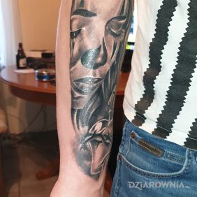 Tatuaż Smutna twarz kobiety z sercem i krzyżem na przedramieniu motyw: twarze styl: realistyczne