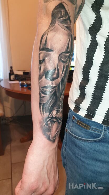 Tattoo Smutna twarz kobiety z sercem i krzyżem in faces motif and realistic style on the forearm