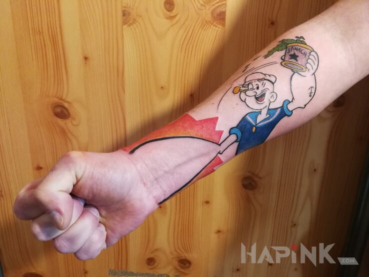 Tattoo Popeye in colorful motif and cartoon / comic book style on the forearm