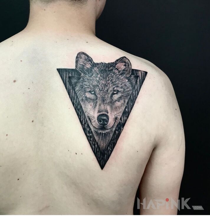 Tattoo Wolf in black and gray motif and realistic style on the shoulder blades