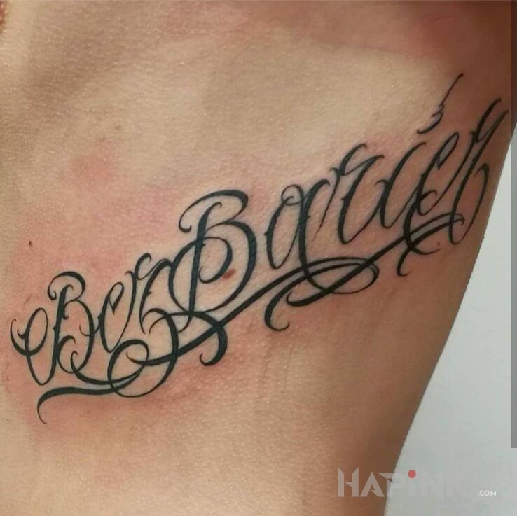 Tattoo Bez Barier in lettering motif and calligraphy style on the ribs