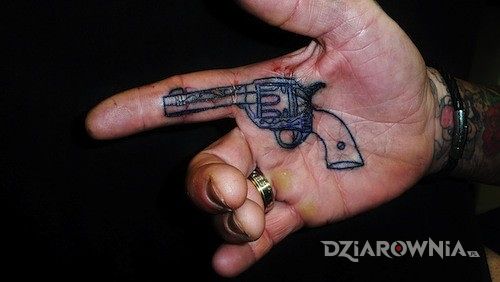 Tatuaż rewolwer w motywie pozostałe na dłoni