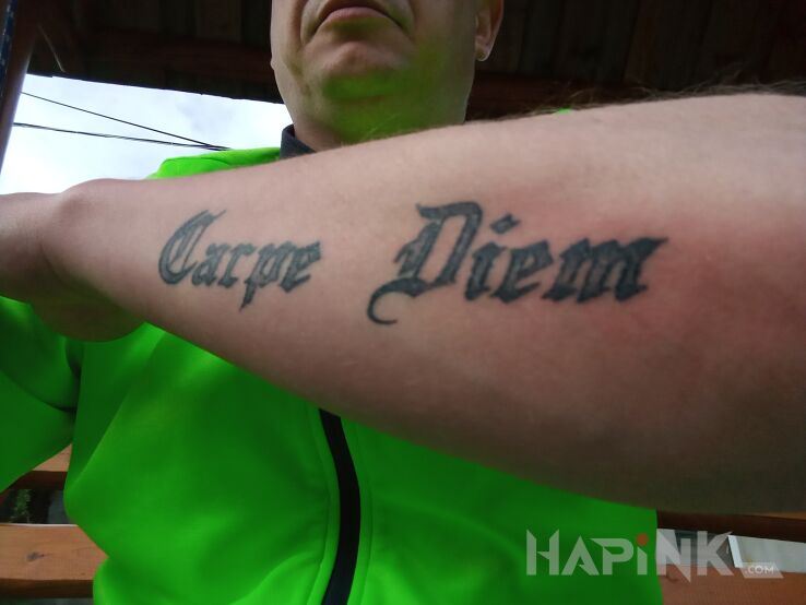Tattoo Carpe Diem in lettering motif and calligraphy style on the forearm